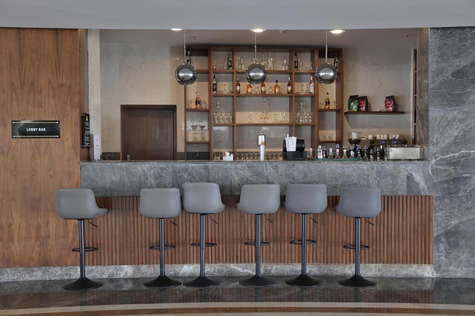 Xanadu Club Makadi Bay lobby bārs ar marmora leti un pelēkiem bāra krēsliem modernā interjerā Hurgadas kūrortā