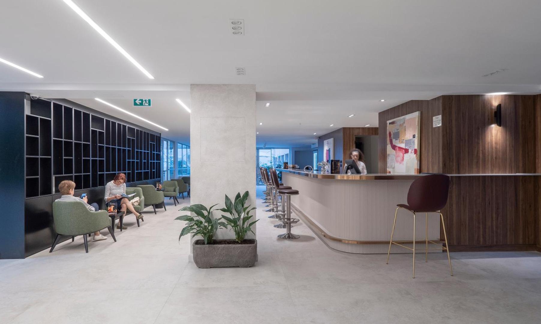 Viesnīcas Hotel Tara plašā lobby zona ar bāru, atpūtas krēsliem un modernu interjeru gaišos toņos
