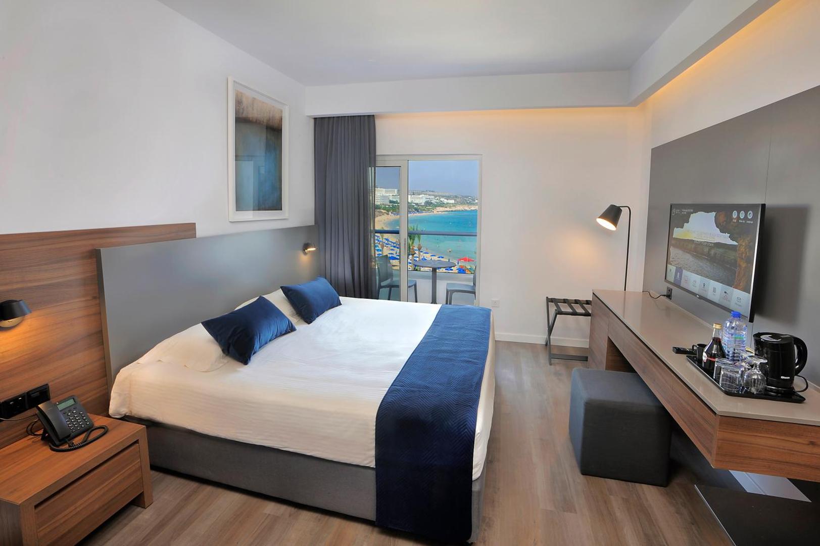 Okeanos Beach Boutique elegants numurs ar ziliem akcentiem un balkonu ar skatu uz Ajanapas līci Kiprā