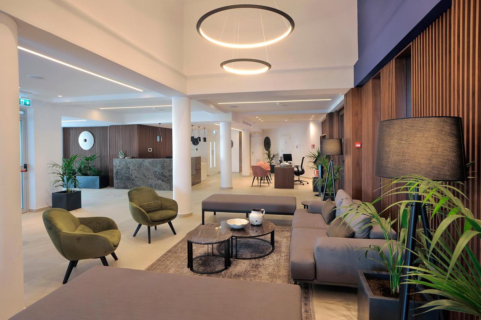 Okeanos Beach Boutique viesnīcas vestibils ar moderniem atpūtas krēsliem, dīvānu un dizaina gaismekļiem Aijanapas kūrortā Kiprā