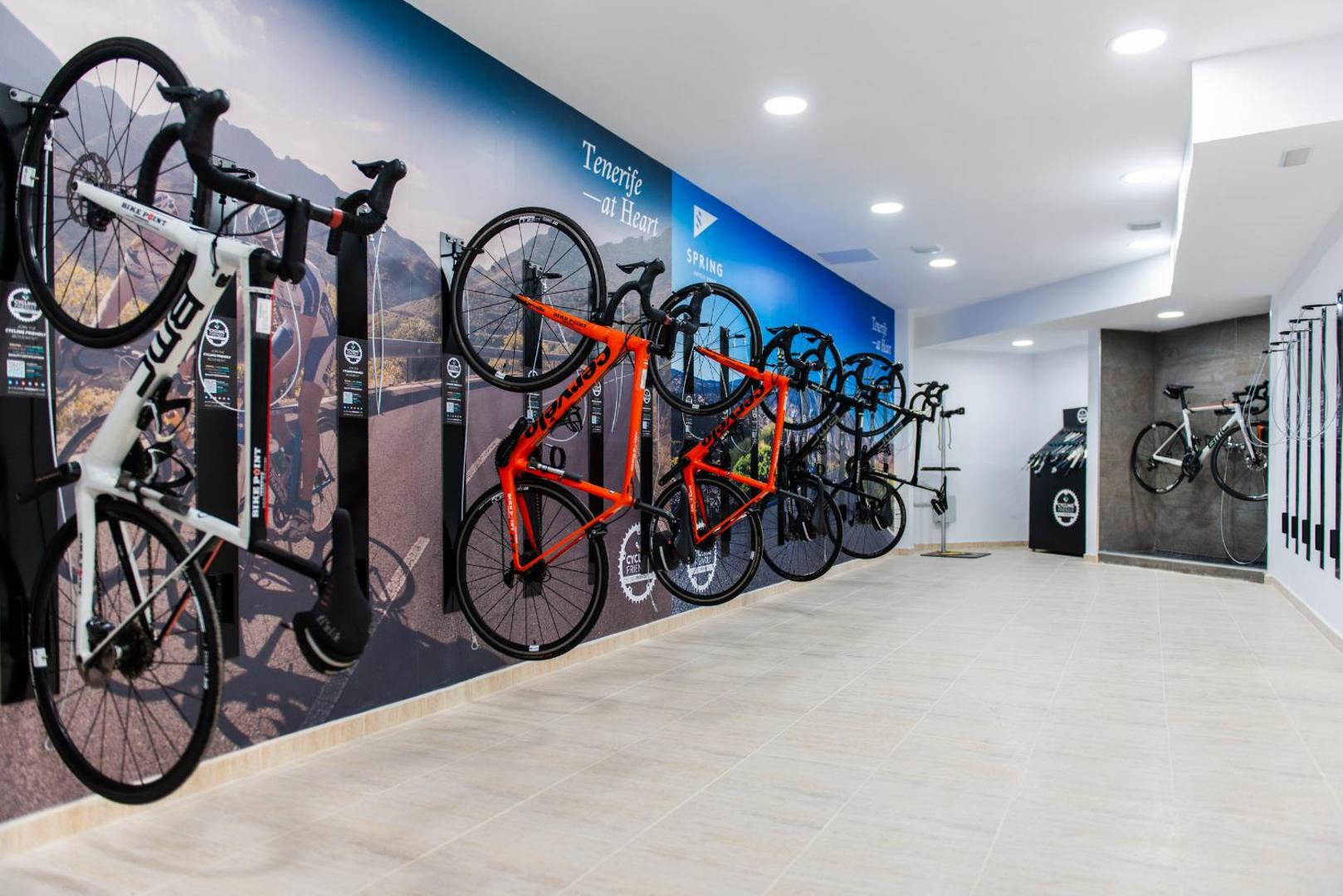 Arona Gran Hotel & Spa velosipēdu glabātuve un servisa centrs — profesionāli šosejas riteņi novietoti pie sienas Tenerifē
