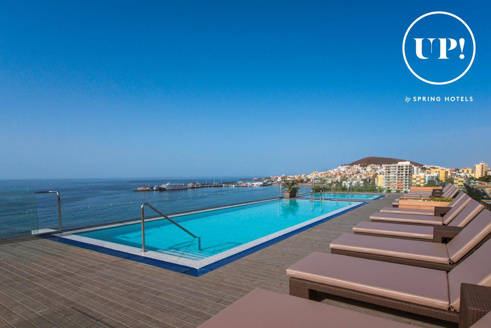 Arona Gran Hotel & Spa bezmalas baseins uz jumta ar skatu uz Los Cristianos pilsētu un okeānu Tenerifē