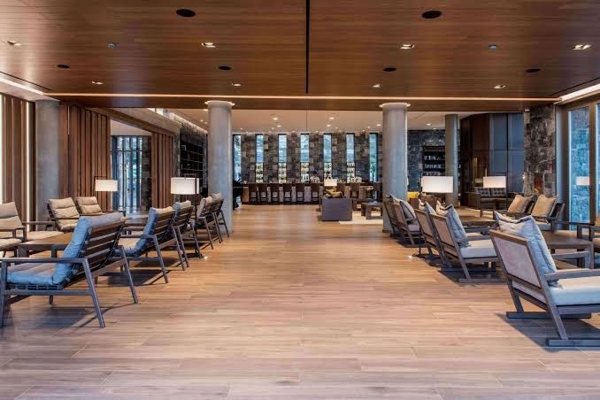 Nana Royal Premium Resort & Spa atpūtas telpa ar ērtiem krēsliem, koka apdari un bāru fonā — mājīga atmosfēra viesiem