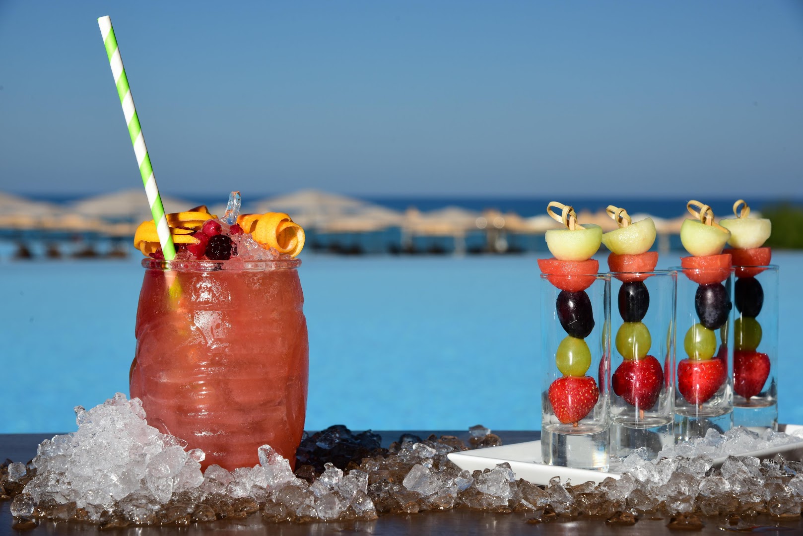 Eksotisks kokteilis un augļu uzkodas uz ledus Nana Royal Premium Resort & Spa baseina malā ar skatu uz jūru