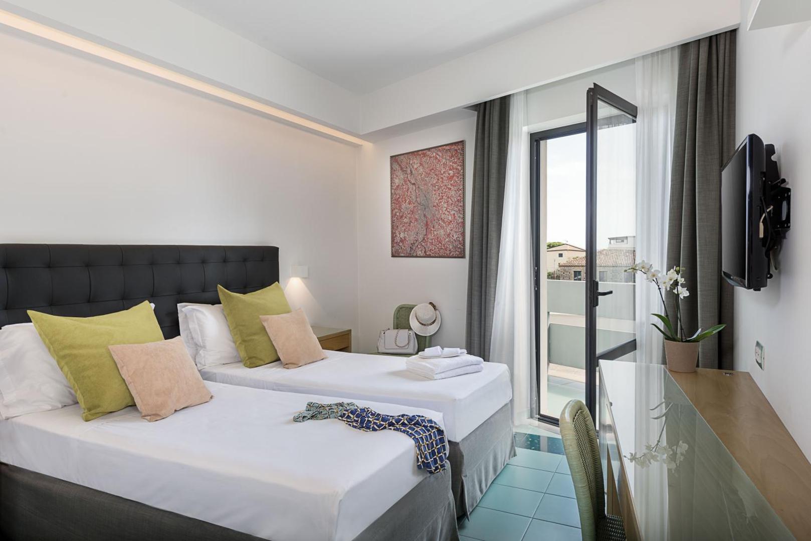 Rada Siri Hotel gaišs divvietīgs numurs ar divām gultām, balkonu un skatu uz pilsētu Kalabrijā, Itālijā