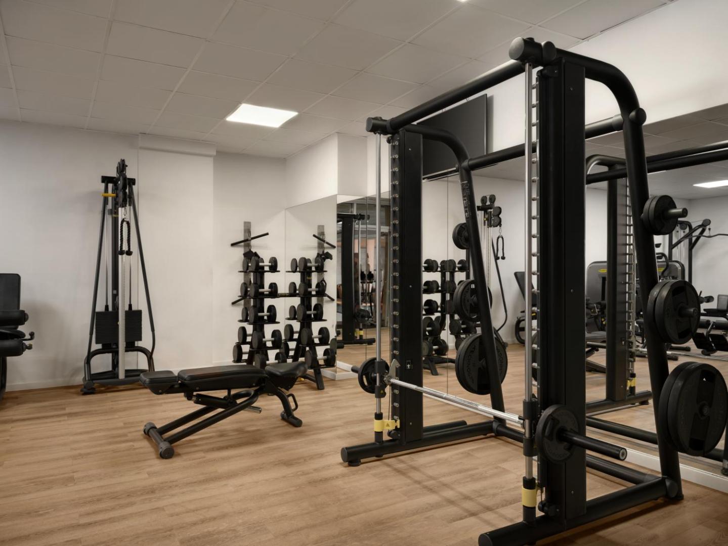 Mediterranean Beach Hotel moderns fitness centrs ar trenažieriem, svariem un spoguļiem aktīvai atpūtai Limasolā