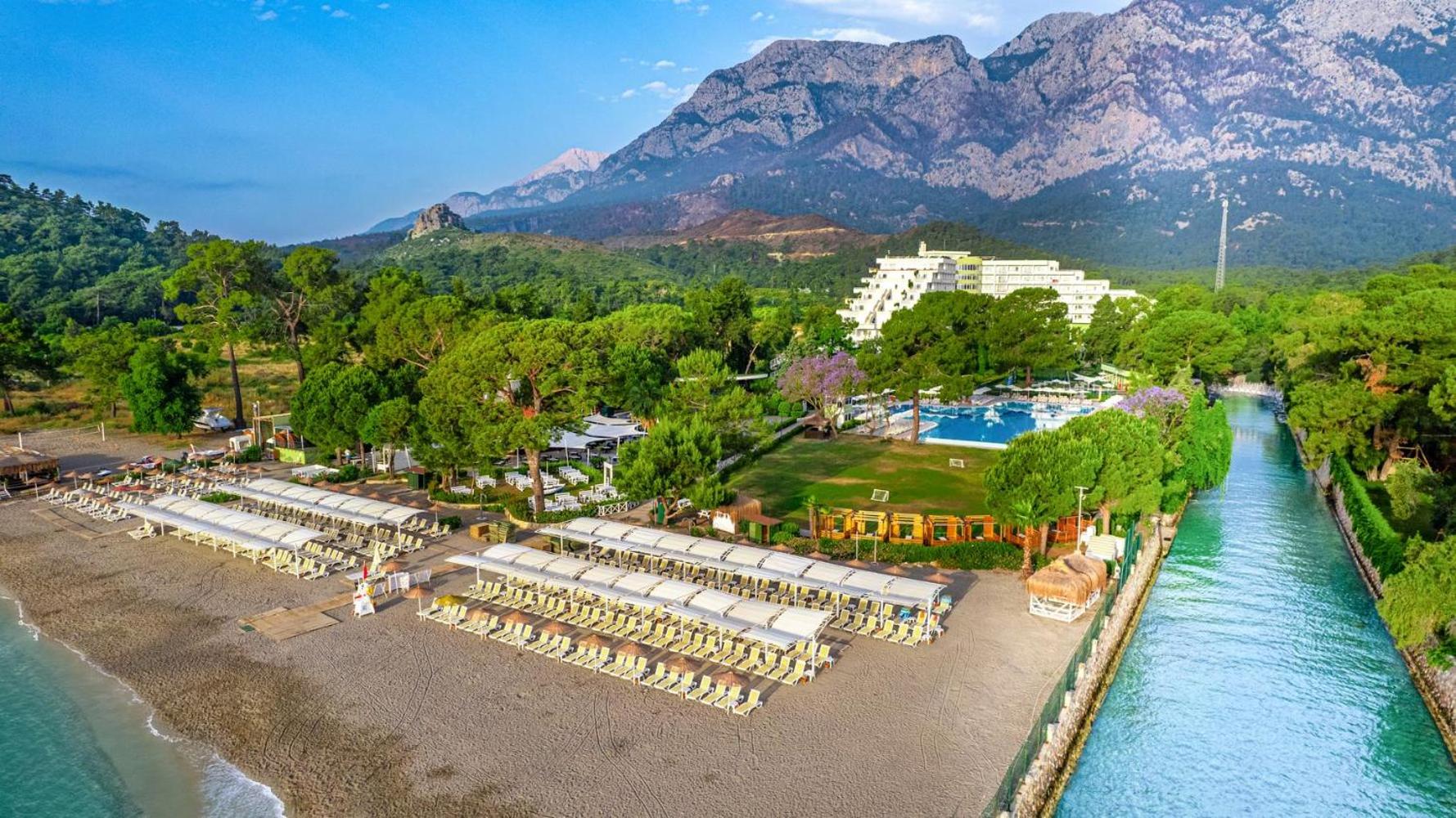 Ma Biche Kemer by Werde Hotels pludmale ar saulessargiem un kalniem fonā.