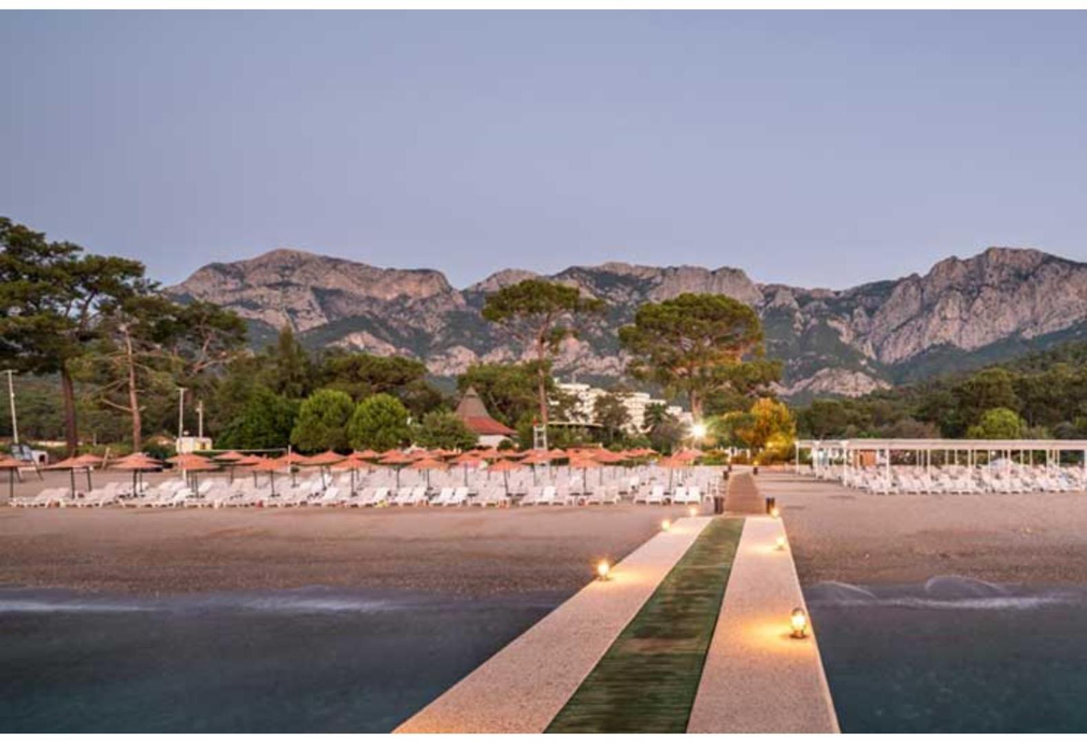 Vakara skats uz Ma Biche Kemer by Werde Hotels pludmali un izgaismotu laipu.