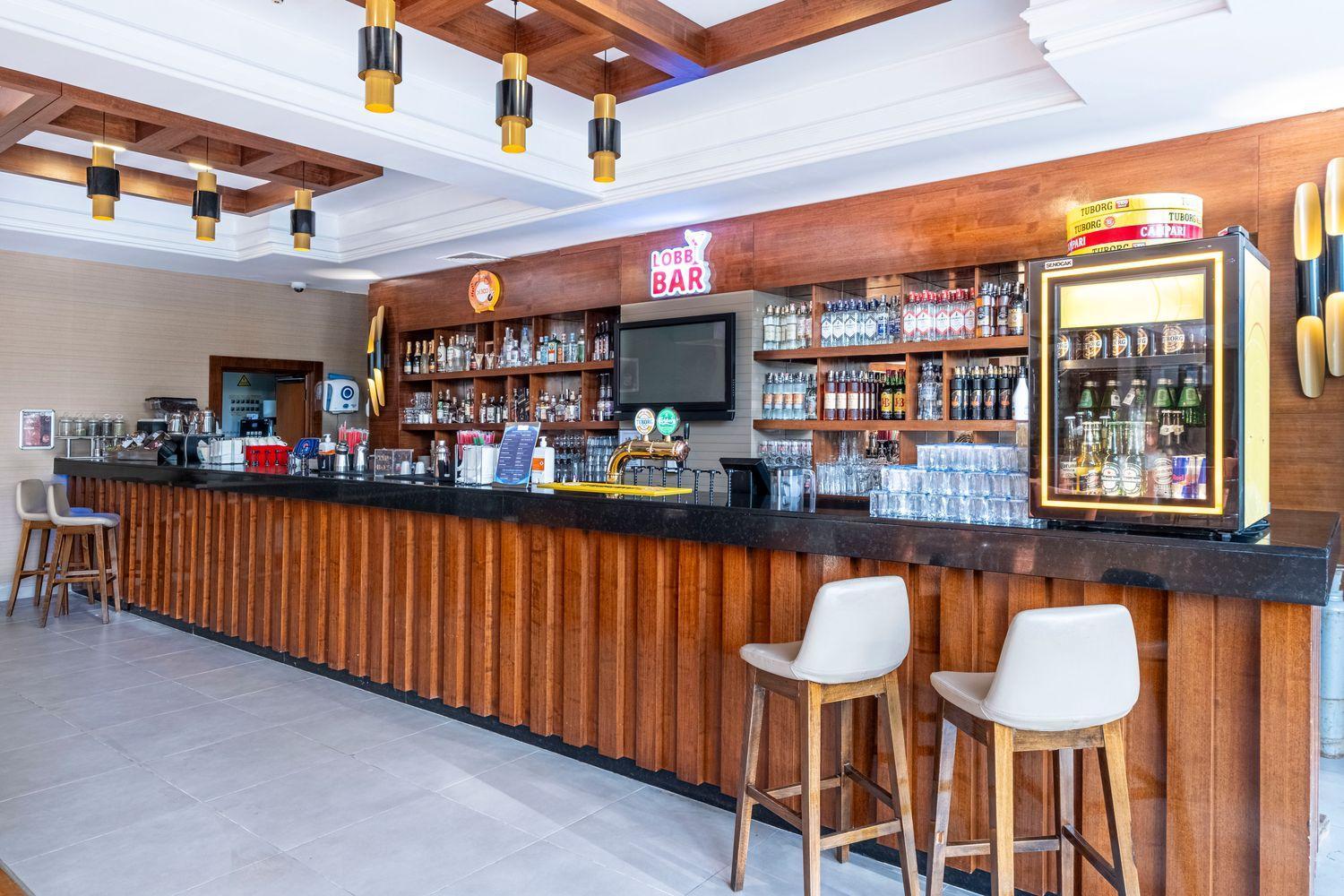 Viesnīcas Ma Biche Kemer by Werde Hotels vestibila bārs ar koka apdari un bāra krēsliem.