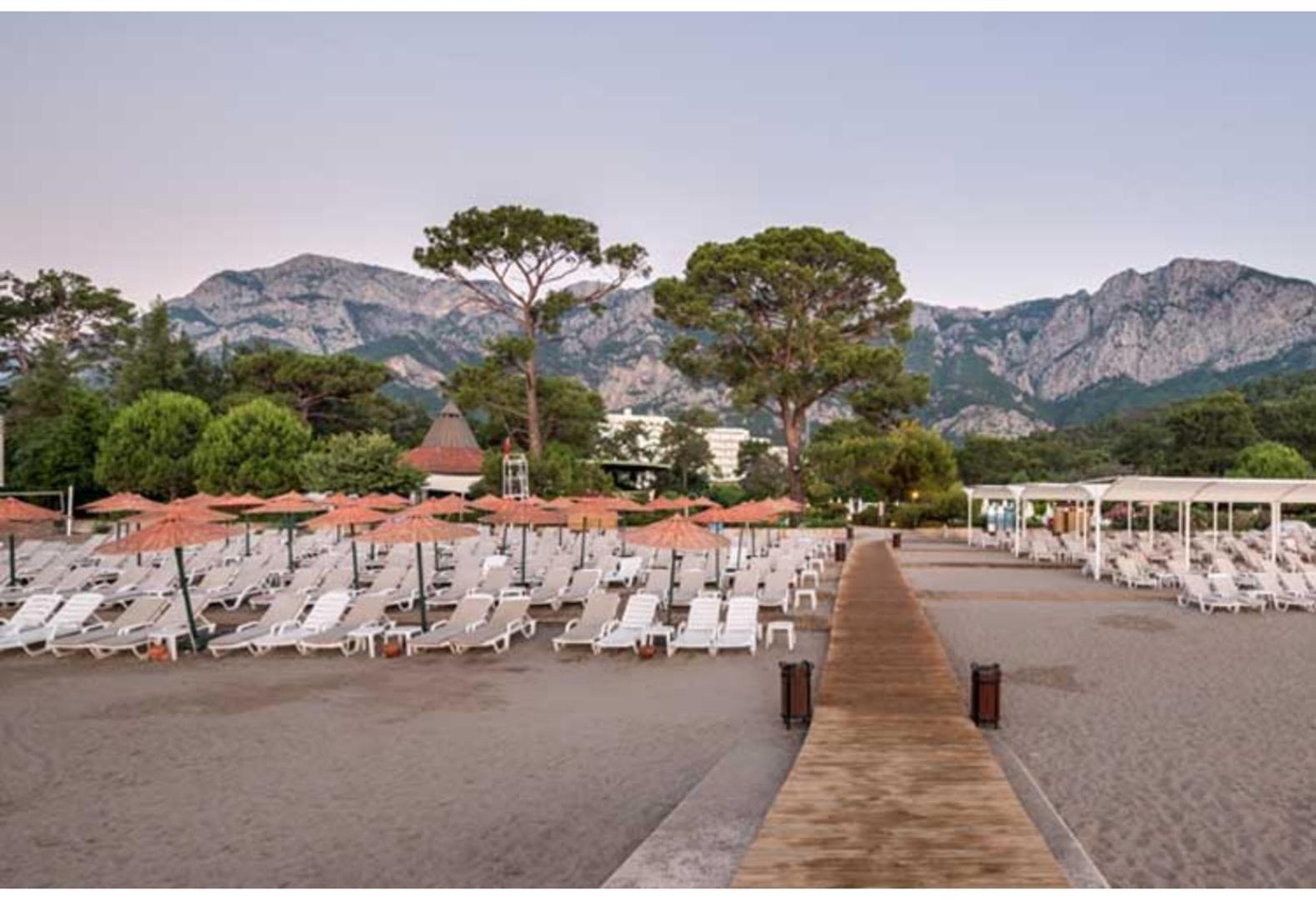 Ma Biche Kemer by Werde Hotels pludmale ar saulessargiem un kalnu panorāmu fonā.