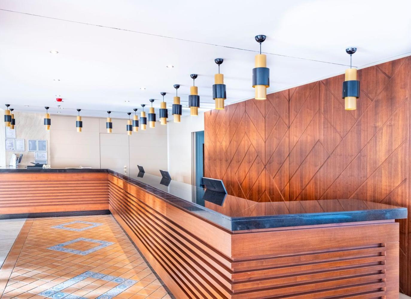 Viesnīcas Ma Biche Kemer by Werde Hotels recepcijas lete ar koka apdari.