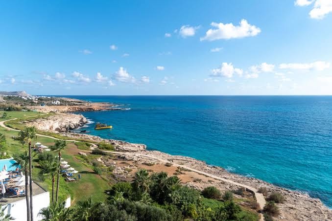 Panorāmas skats uz Vidusjūras piekrasti un klinšaino krastu pie Grecian Sands viesnīcas Aijanapā, Kiprā