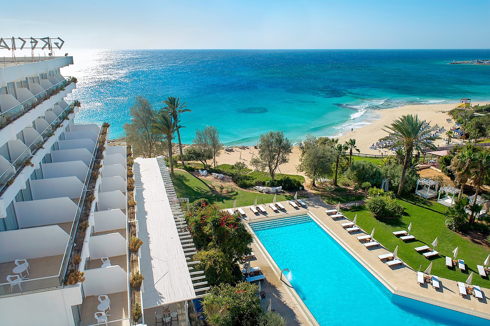 Grecian Sands viesnīcas panorāmas skats uz āra baseinu, smilšu pludmali un tirkīzzilo Vidusjūru Ajanapā, Kiprā