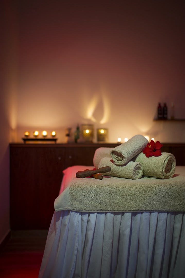 Grecian Sands viesnīcas spa procedūru telpa ar masāžas galdu, svecēm un sarullētiem dvieļiem mierīgai atpūtai Ajanapā, Kiprā