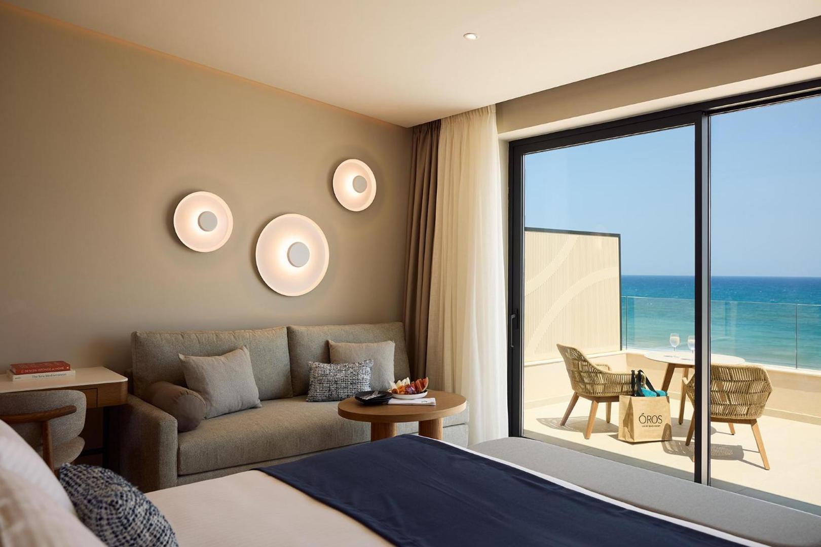 Viesnīcas numura interjers ar balkonu, no kura paveras skats uz jūru.