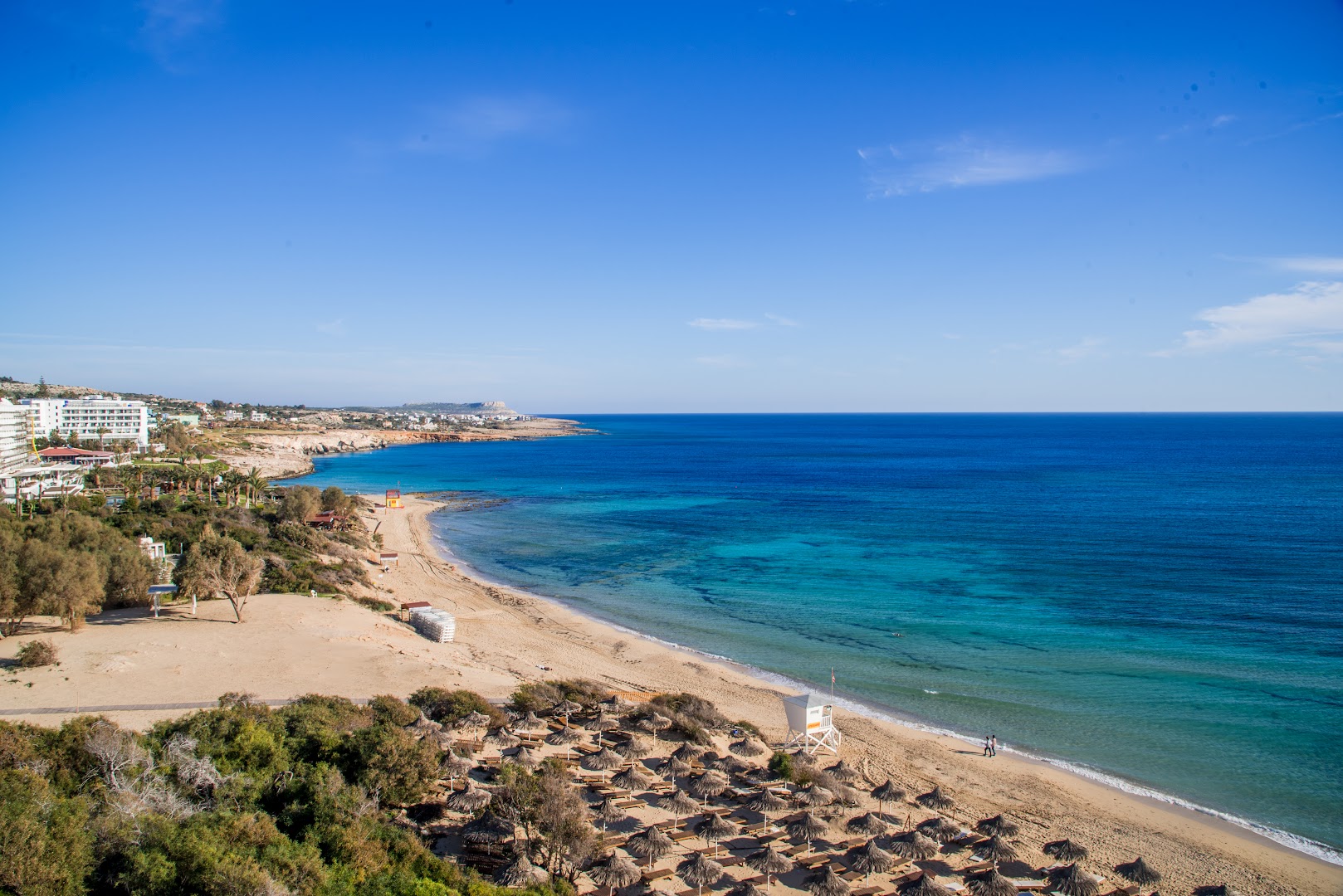 Panorāmas skats uz Grecian Bay privāto smilšu pludmali un tirkīzzilo Vidusjūru Aijanapā, Kiprā, no augšējā skatu punkta.
