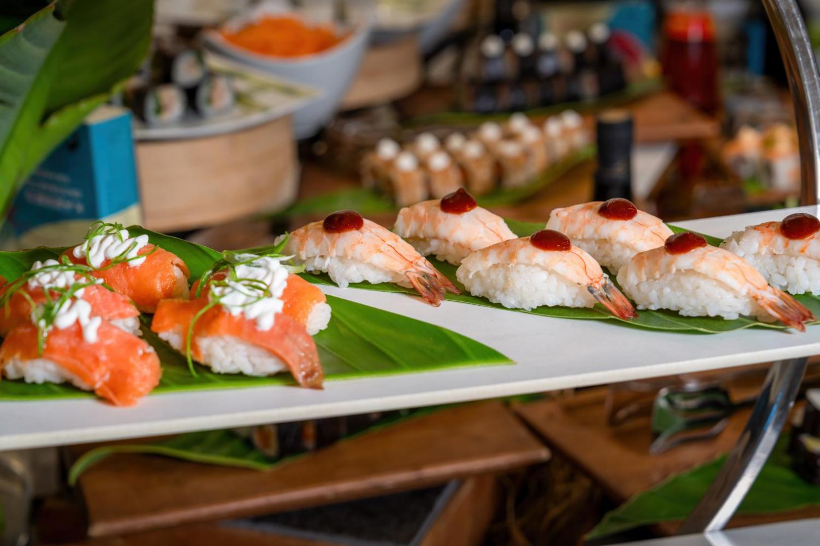 Tuvplāns ar svaigām suši uzkodām, kas dekorētas ar garnelēm un lasi.