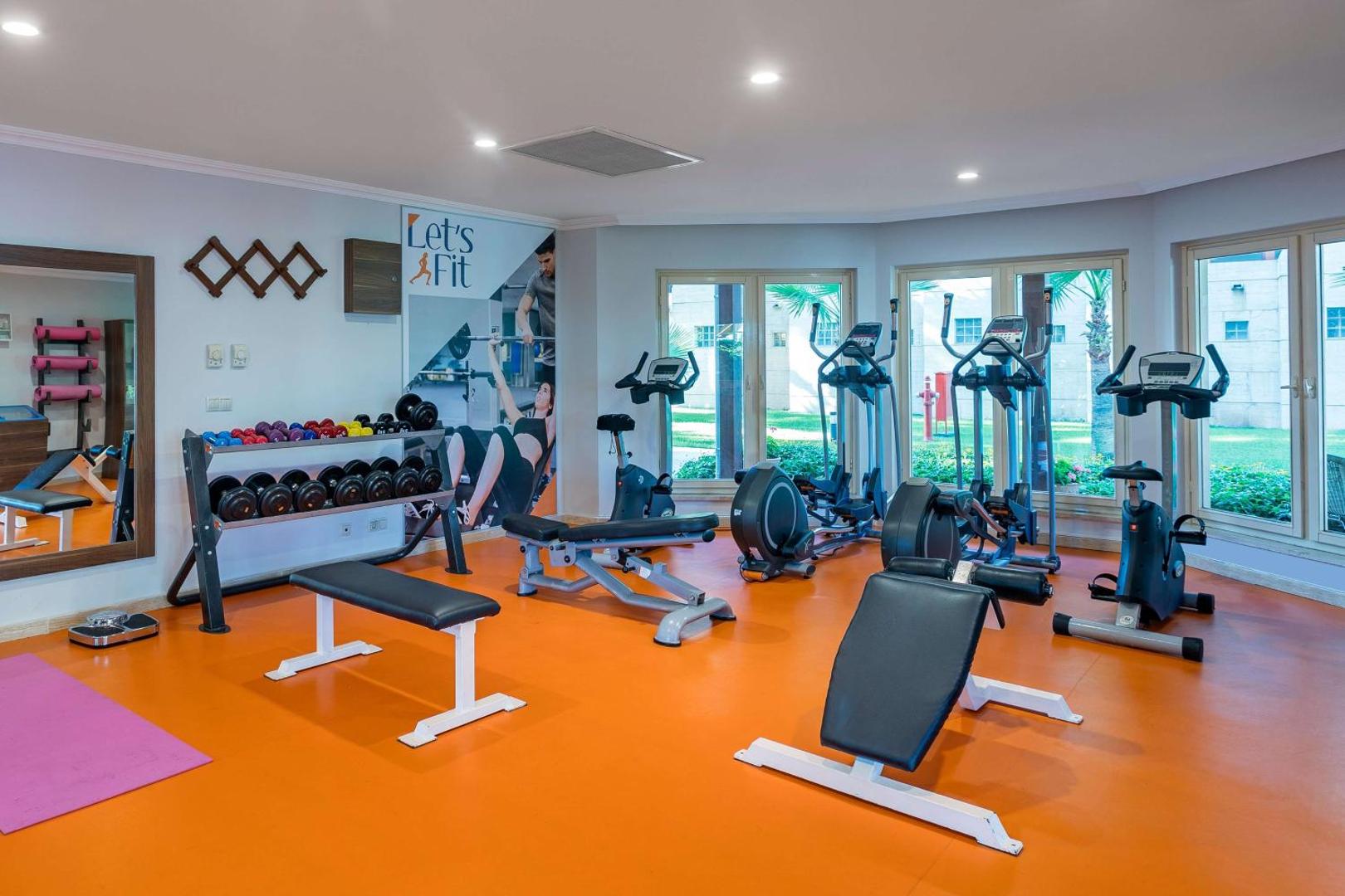 Seven Seas Hotel Life fitness centrs ar moderniem trenažieriem, svariem un skatu uz dārzu caur lieliem logiem