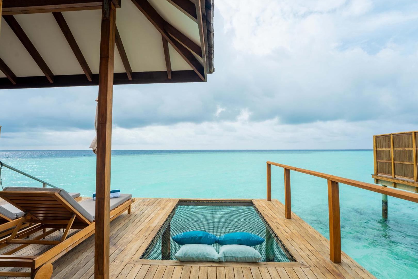 Veligandu Maldives Resort Island ūdens villas terase ar iebūvētu tīklu atpūtai virs okeāna un sauļošanās krēsliem