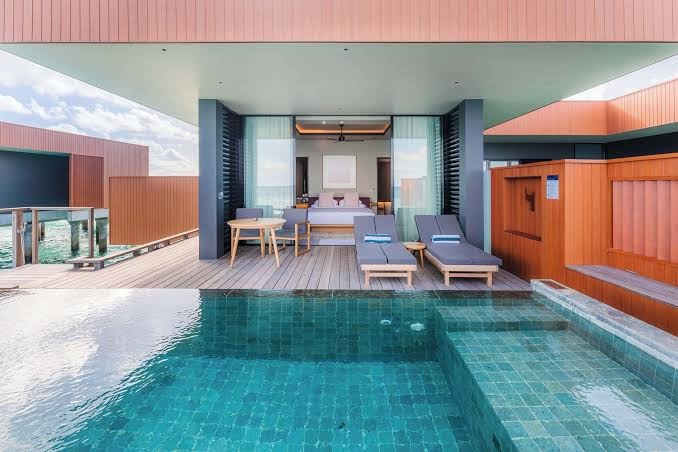 Veligandu Maldives Resort Island ūdens villas terase ar privātu baseinu, sauļošanās krēsliem un skatu uz okeānu no numura
