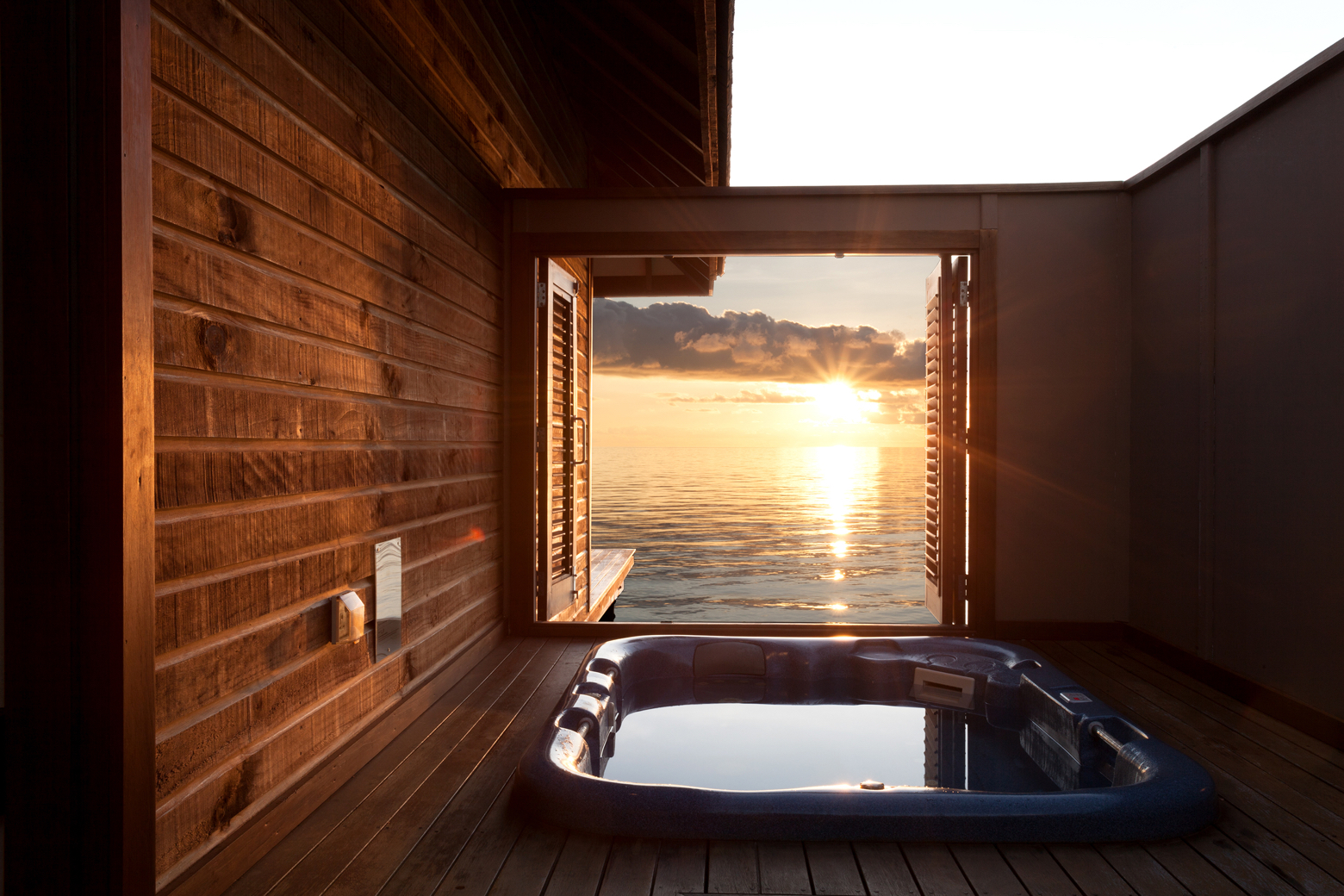 Veligandu Maldives Resort Island privātā džakuzi vanna uz koka terases ar skatu uz saulrietu okeāna horizontā