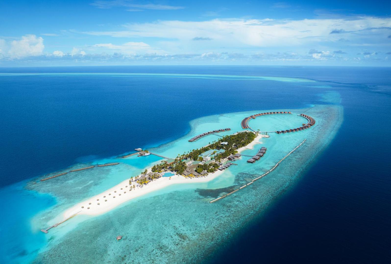 Veligandu Maldives Resort Island aerofoto uzņēmums no putna lidojuma — kūrorta sala ar baltām smiltīm, tirkīza lagūnu un bungalo virs ūdens