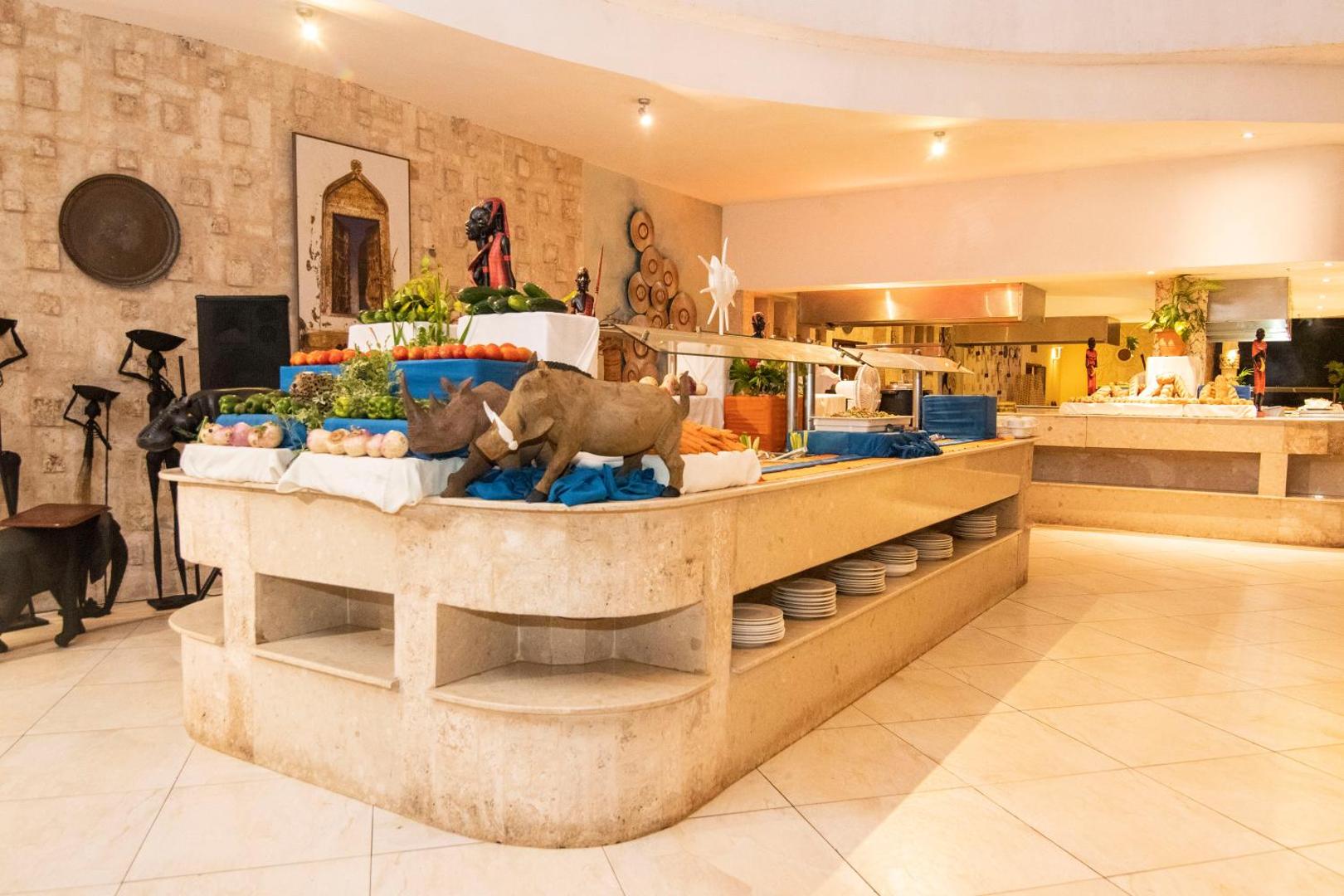 Leopard Beach Resort & Spa bufetes galds ar svaigiem dārzeņiem un afrikāņu stila dekorācijām restorāna zonā
