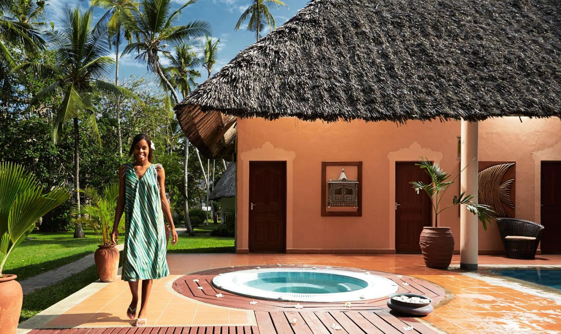 Neptune Village Beach Resort āra džakuzi pie bungalo ēkas Zanzibārā — palmu dārzs un tropu vide atpūtai