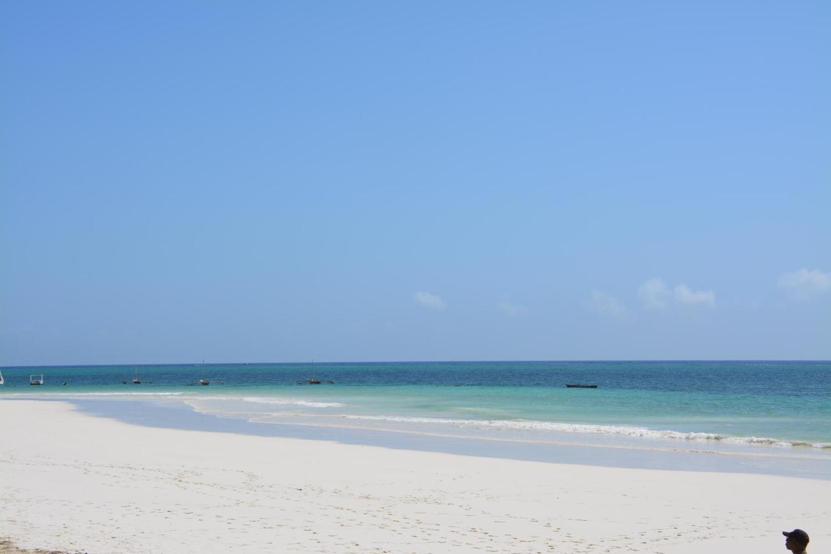 Plašs skats uz Indijas okeānu un balto smilšu pludmali pie Neptune Village Beach Resort Zanzibārā