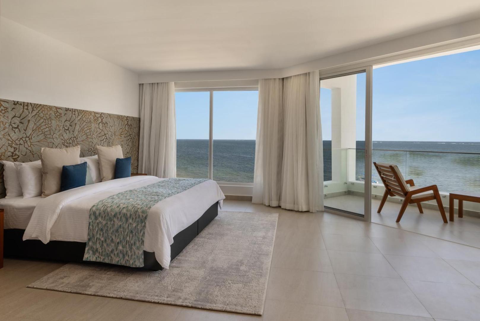 Bamburi Beach Hotel gaišs numurs ar lielu gultu, panorāmas logiem un balkonu ar skatu uz Indijas okeānu