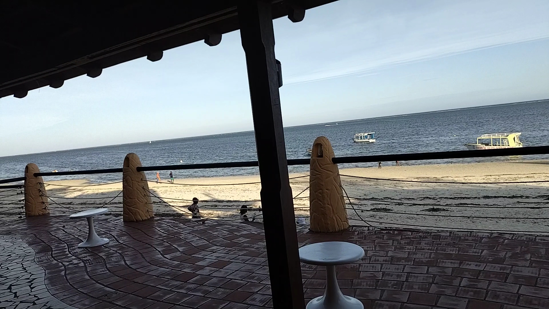 Skats no Bamburi Beach Hotel segtās terases uz smilšu pludmali un okeānu ar laivām tālumā Mombasā