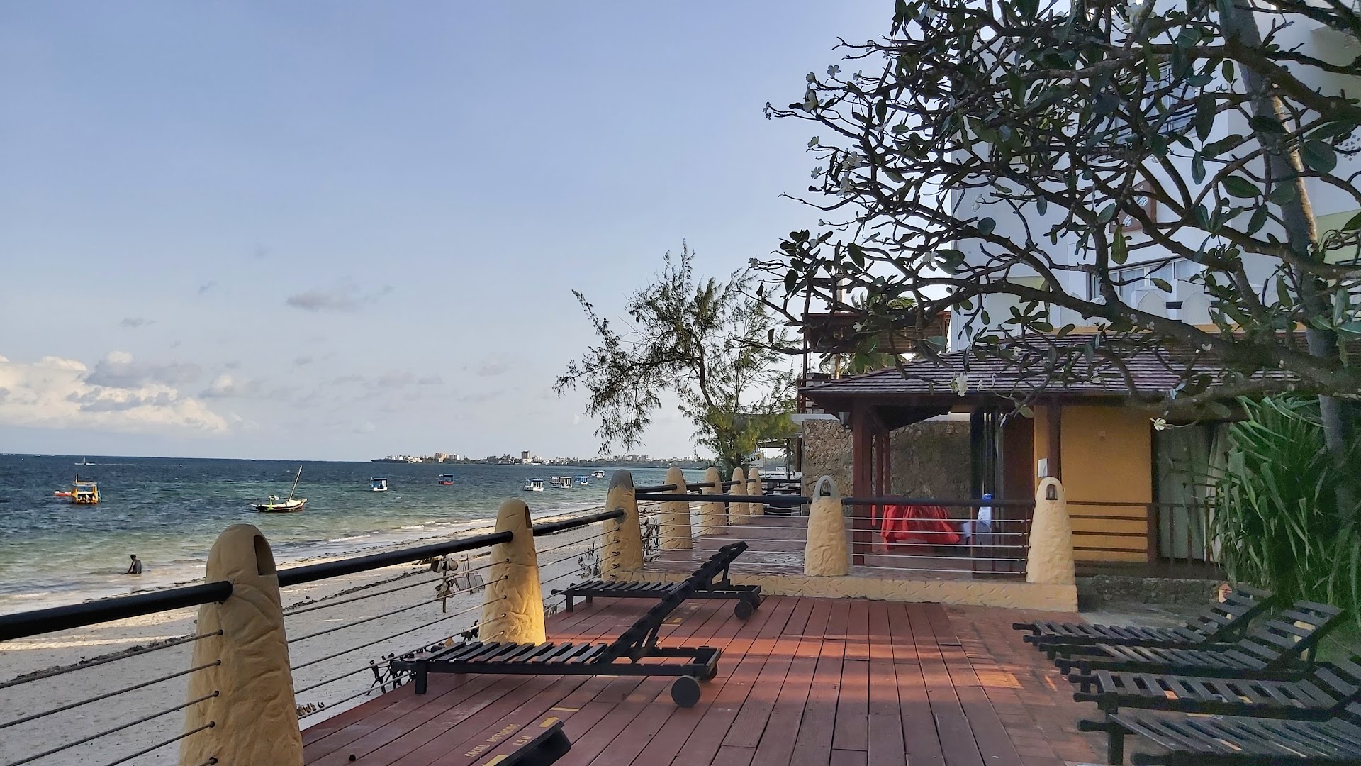 Bamburi Beach Hotel koka sauļošanās terase ar zviļņiem un skatu uz Indijas okeānu Mombasas piekrastē saulrietā