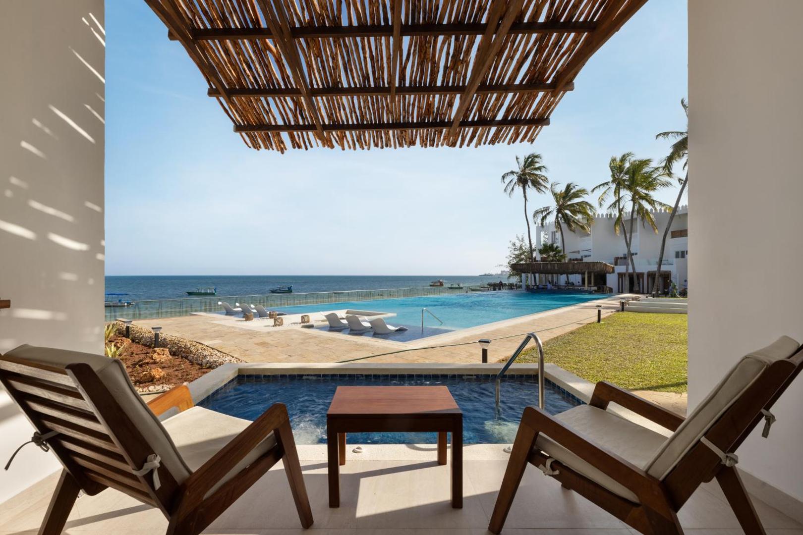 Bamburi Beach Hotel āra baseinu zona ar sauļošanās krēsliem, palmām un skatu uz okeānu Kenijas piekrastē