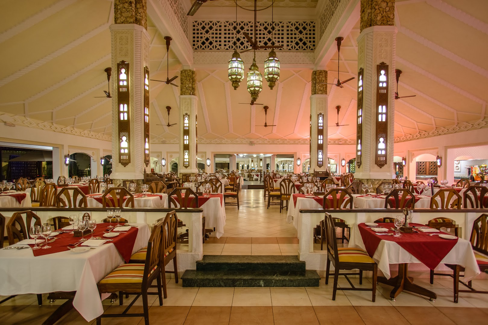 Sarova White Sands Beach Resort & Spa galvenais restorāns ar augstiem griestiem, greznām kolonnām un tradicionālām lustrām Mombasā