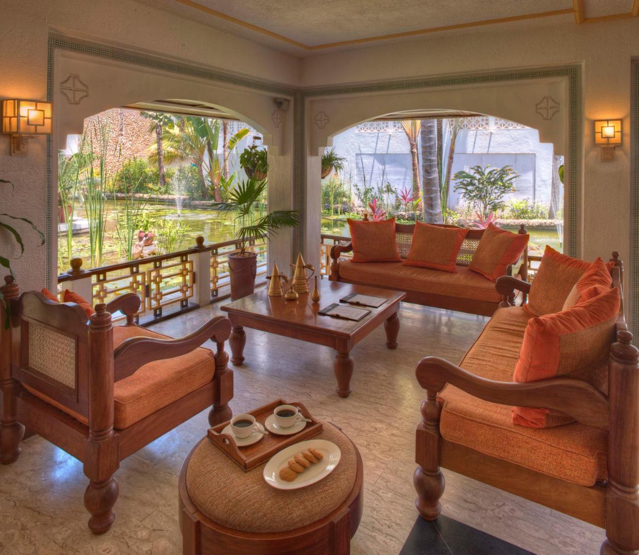 Sarova White Sands Beach Resort & Spa atpūtas zona ar koka mēbelēm un skatu uz iekšpagalmu ar dekoratīvu dīķi