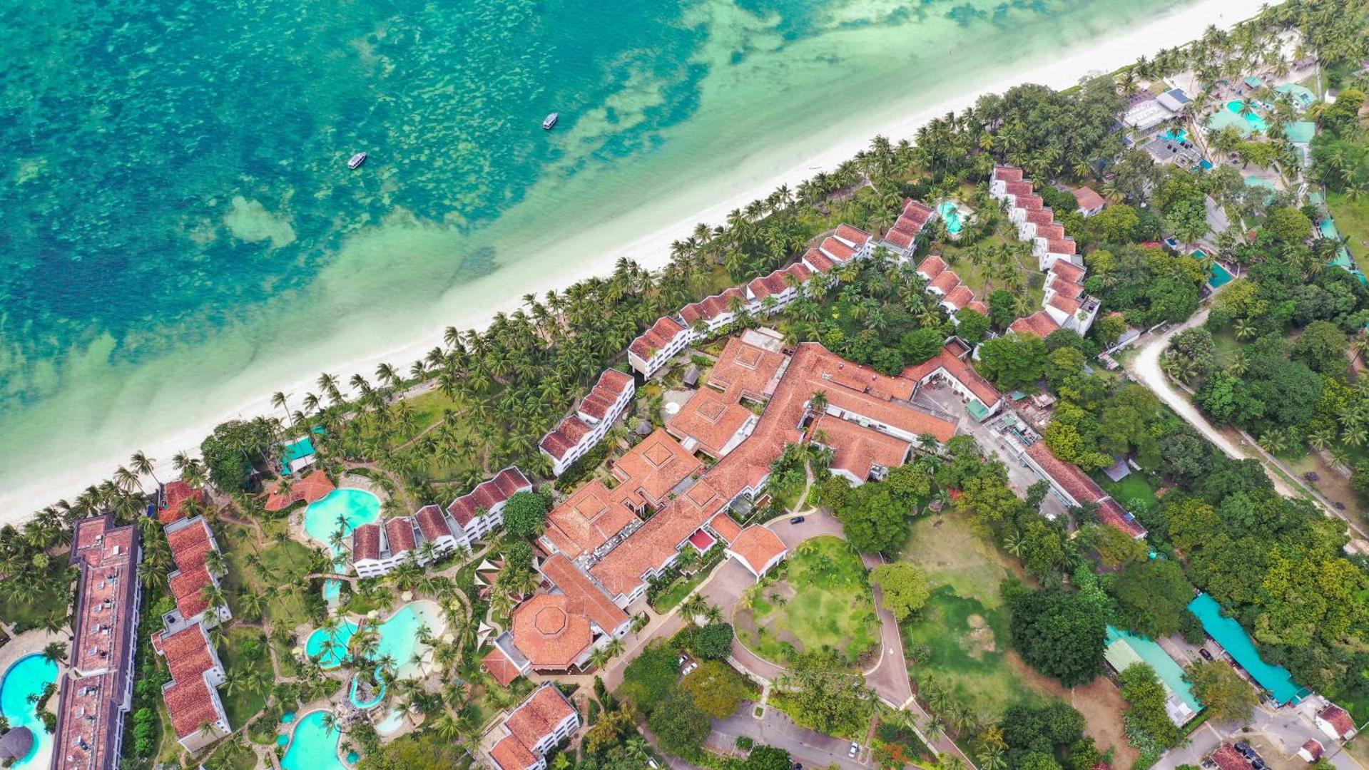 Sarova White Sands Beach Resort & Spa aerofoto uzņēmums no augšas — viesnīcas komplekss pie tirkīzzilas jūras un baltu smilšu pludmales Mombasā