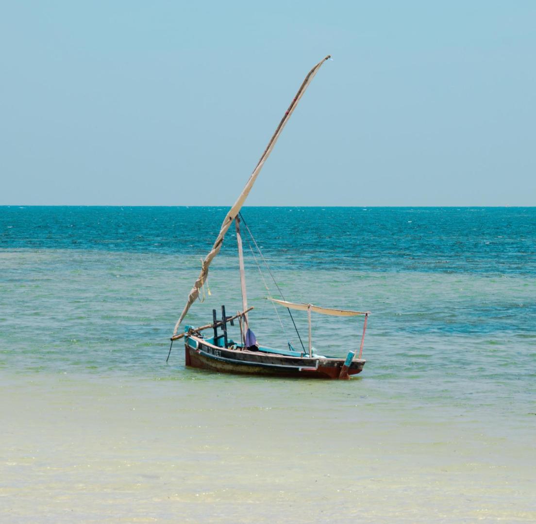 PrideInn Flamingo Beach Resort & Spa tradicionālā dhow laiva tirkīzzilā Indijas okeāna ūdenī pie Mombasas krastiem Kenijā