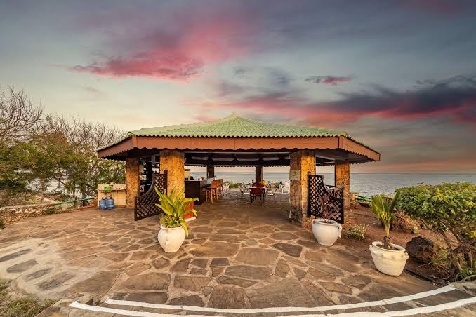 PrideInn Flamingo Beach Resort & Spa āra bārs zem nojumes piekrastē saulrieta laikā ar skatu uz okeānu