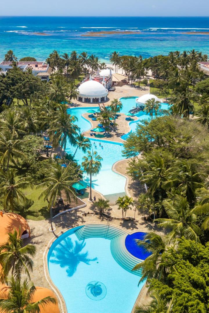 Southern Palms Beach Resort aerofoto ar plašiem baseiniem, palmām un Indijas okeāna piekrasti Diani pludmalē, Kenijā