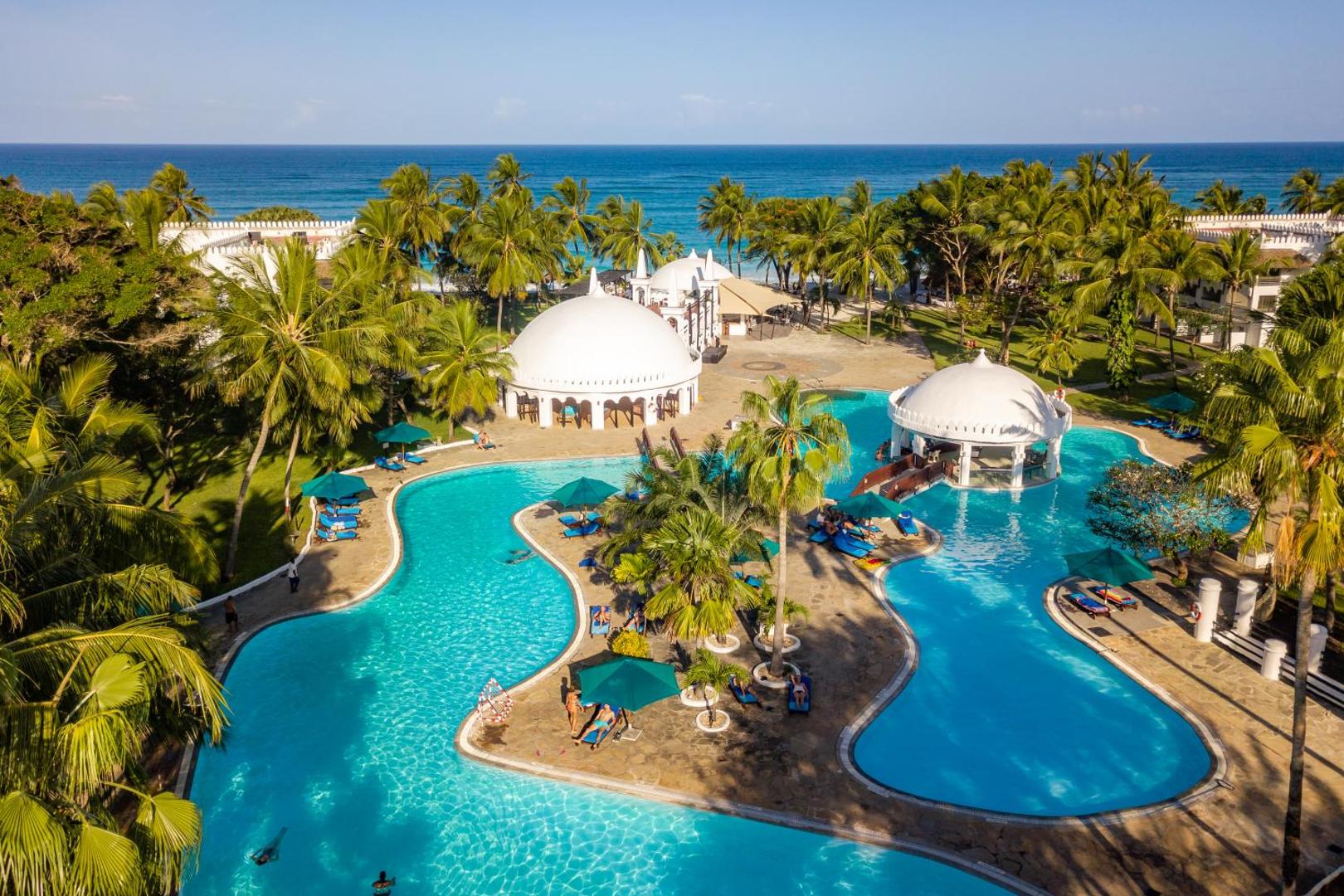 Southern Palms Beach Resort skats no augšas uz plašo baseinu kompleksu, palmām un Indijas okeāna piekrasti Dianī pludmalē, Kenijā.