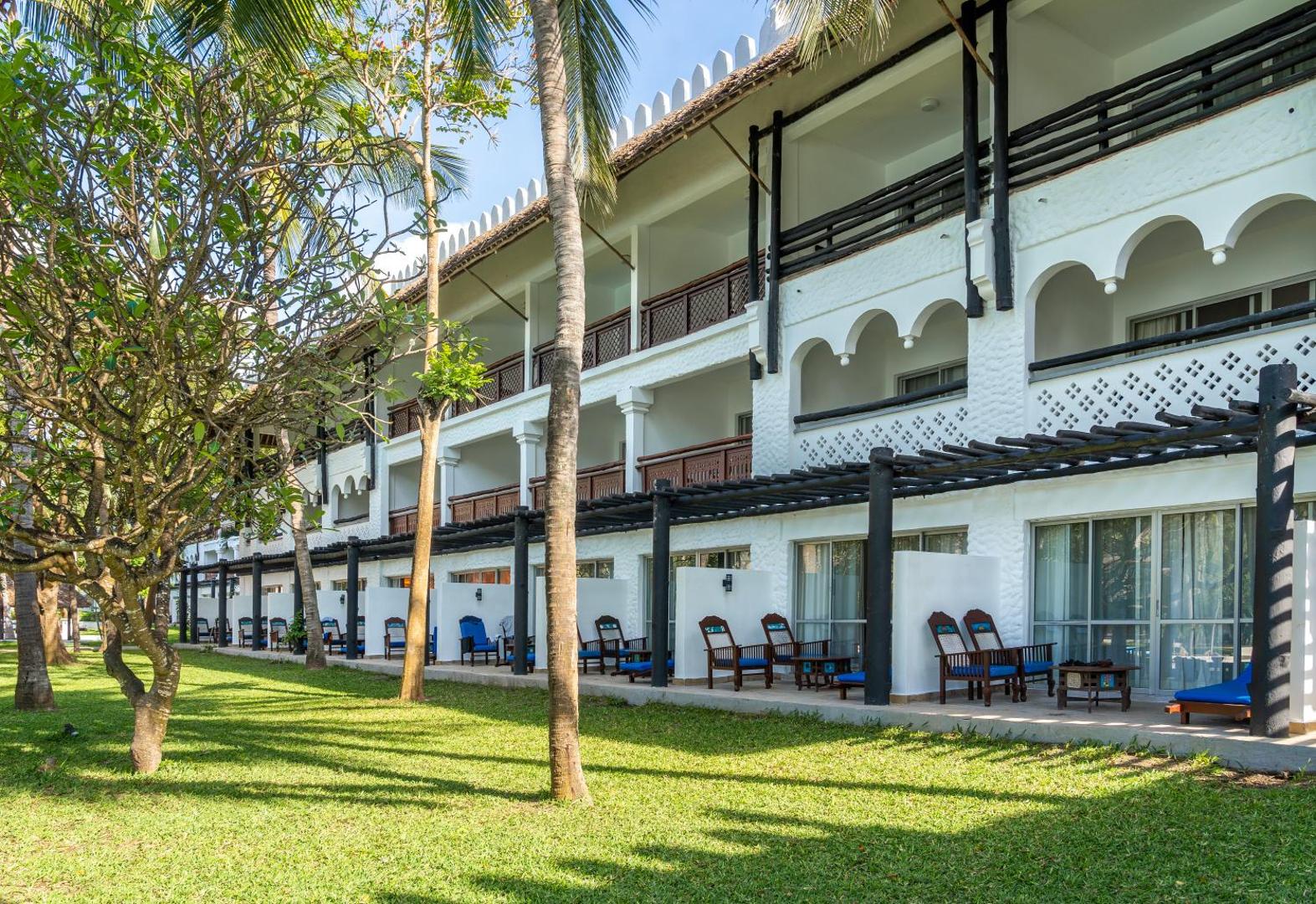 Southern Palms Beach Resort viesnīcas korpuss ar balkoniem un terasēm, ko ieskauj kopts zālājs un palmas Dianī, Kenijā
