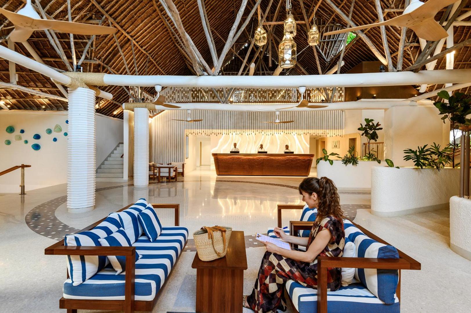 Diamond Leisure Beach & Golf Resort plašais lobby ar autentisku koka siju jumtu, svītrainiem dīvāniem un recepcijas zonu