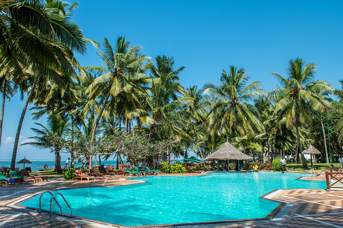 Serena Beach Resort & Spa baseins ar dzidru ūdeni un tropu dārzu Mombasas piekrastē — sauļošanās krēsli un okeāna tuvums
