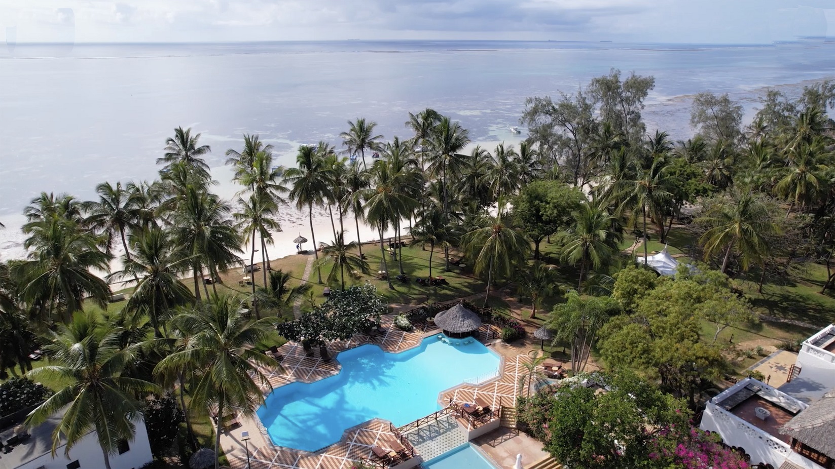 Serena Beach Resort & Spa aerofoto skats uz baseinu, palmu birzi un balto smilšu pludmali Mombasas piekrastē