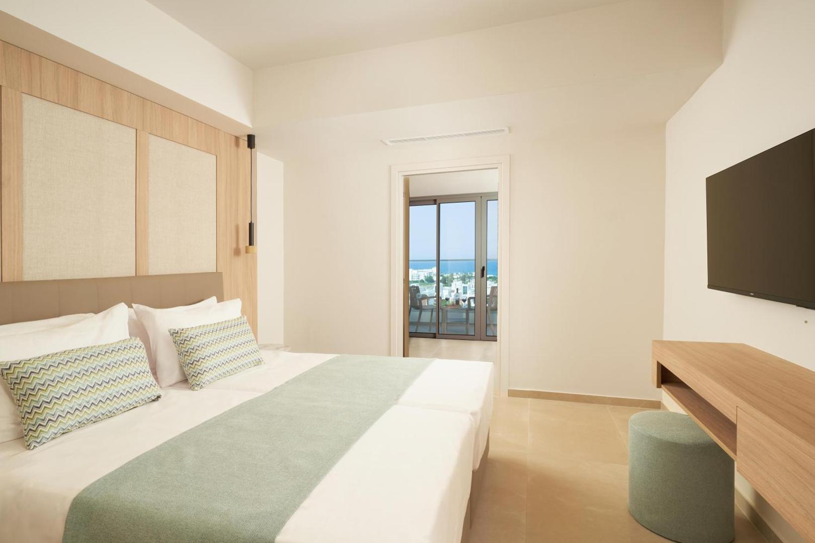 Maris Grand Waterpark Resort gaišs divvietīgs numurs ar skatu uz jūru, modernu interjeru, televizoru un izeju uz balkonu Kiprā