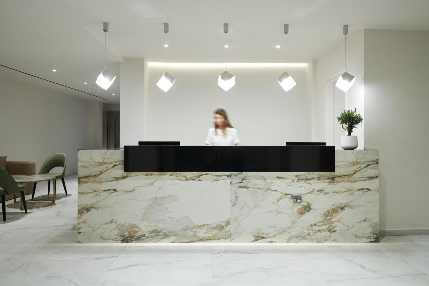 Maris Grand Waterpark Resort recepcijas lete ar marmora apdari un moderniem gaismekļiem viesnīcas reģistratūrā