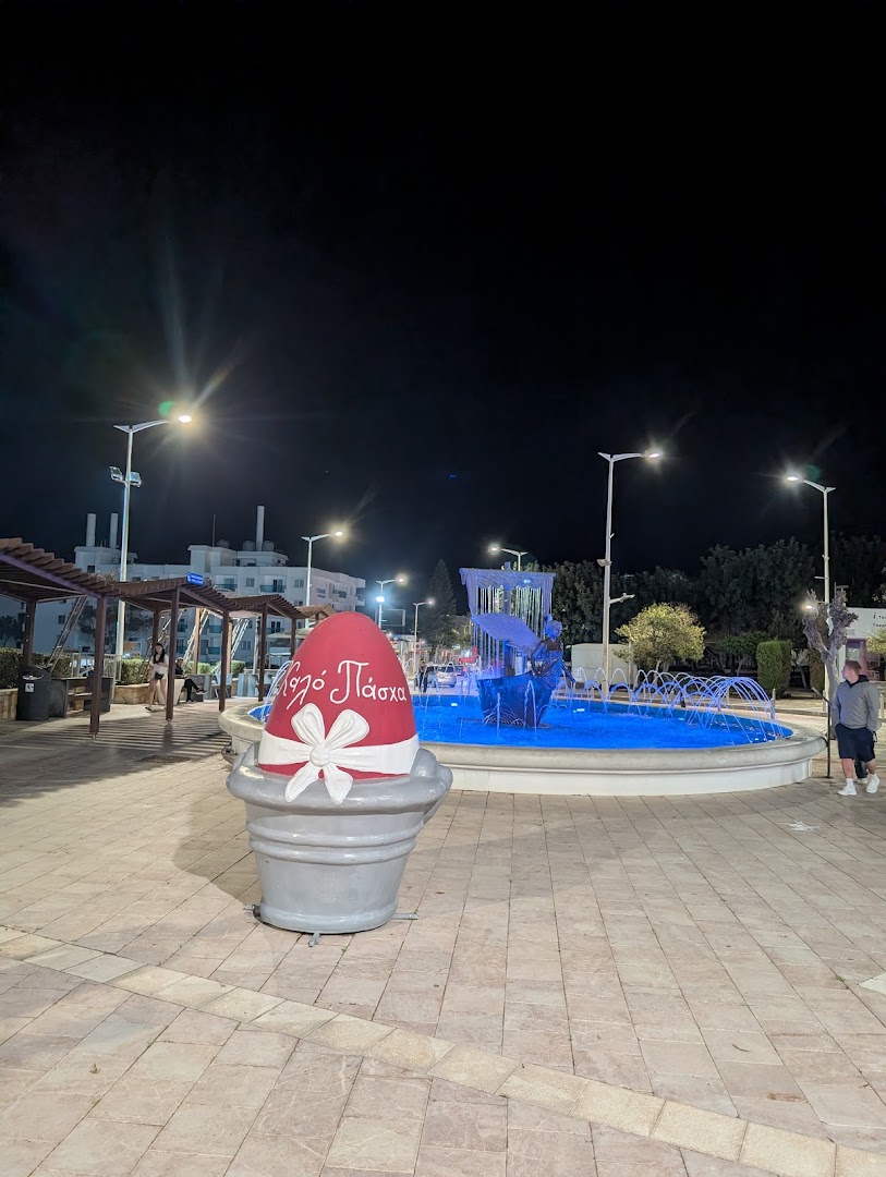 Maris Grand Waterpark Resort apkārtnes laukums naktī ar izgaismotu strūklaku un Lieldienu dekorāciju Rodas salas kūrortpilsētā Grieķijā.
