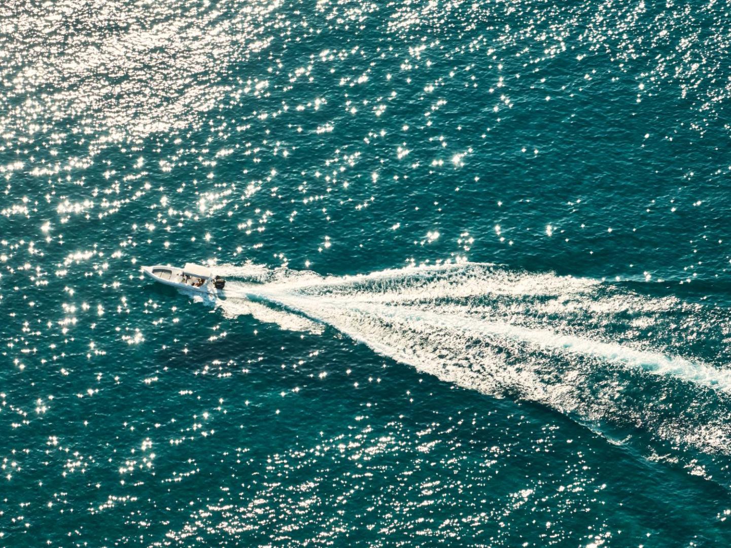 Motorlaiva brauc pa mirdzošu Jonijas jūras ūdeni netālu no Atlantica Grand Mediterraneo Resort kūrorta Korfu
