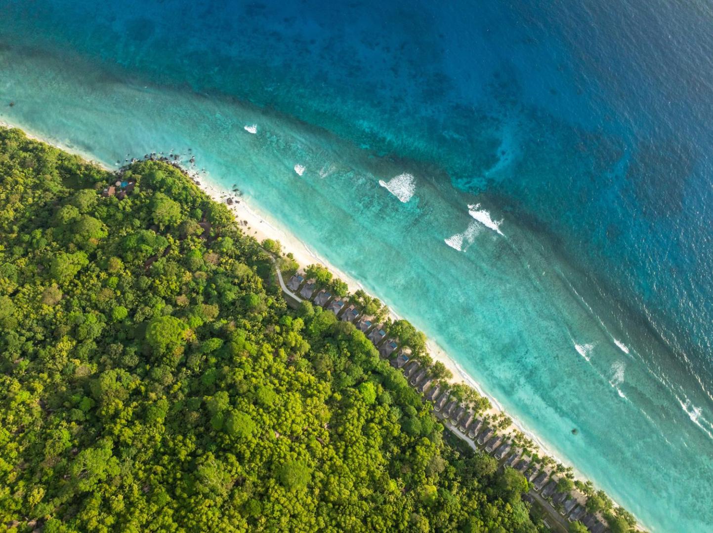 NIVA Labriz Seychelles viesnīcas skats no putna lidojuma uz tirkīzzilo okeānu, balto smilšu pludmali un blīvu tropu mežu piekrastē