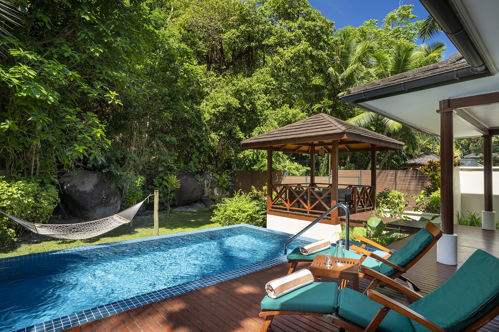 NIVA Labriz Seychelles villas pagalms ar baseinu, šūpuļtīklu starp kokiem, koka lapeni un zaļiem sauļošanās krēsliem